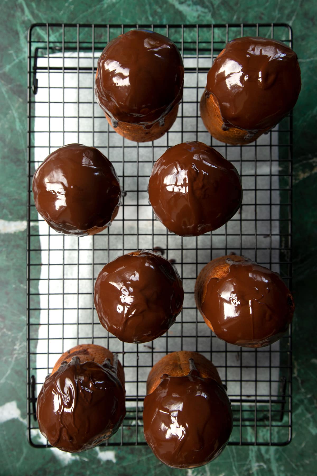 8 cooled panettone on a wire rack, drizzled with melted chocolate.