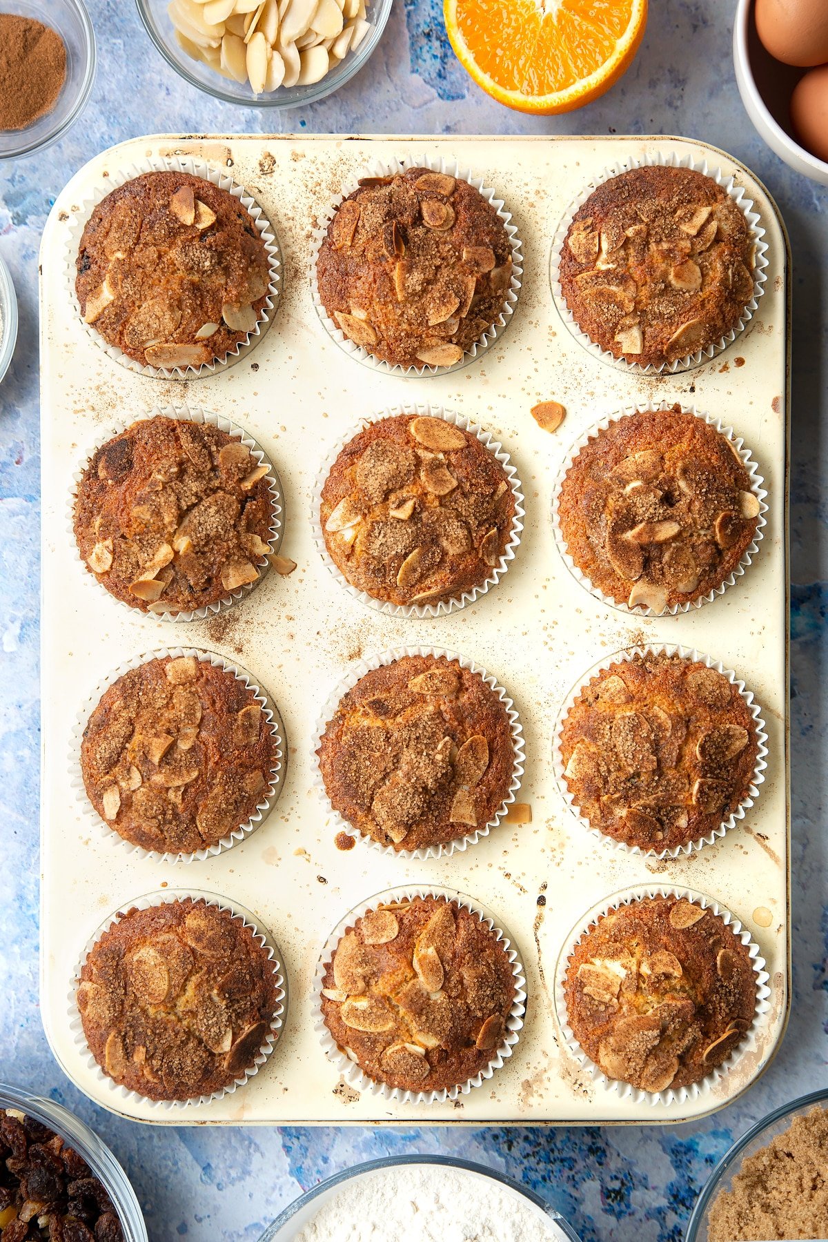 Overhead shot of baked orange and cinnamon muffins in a muffin tray