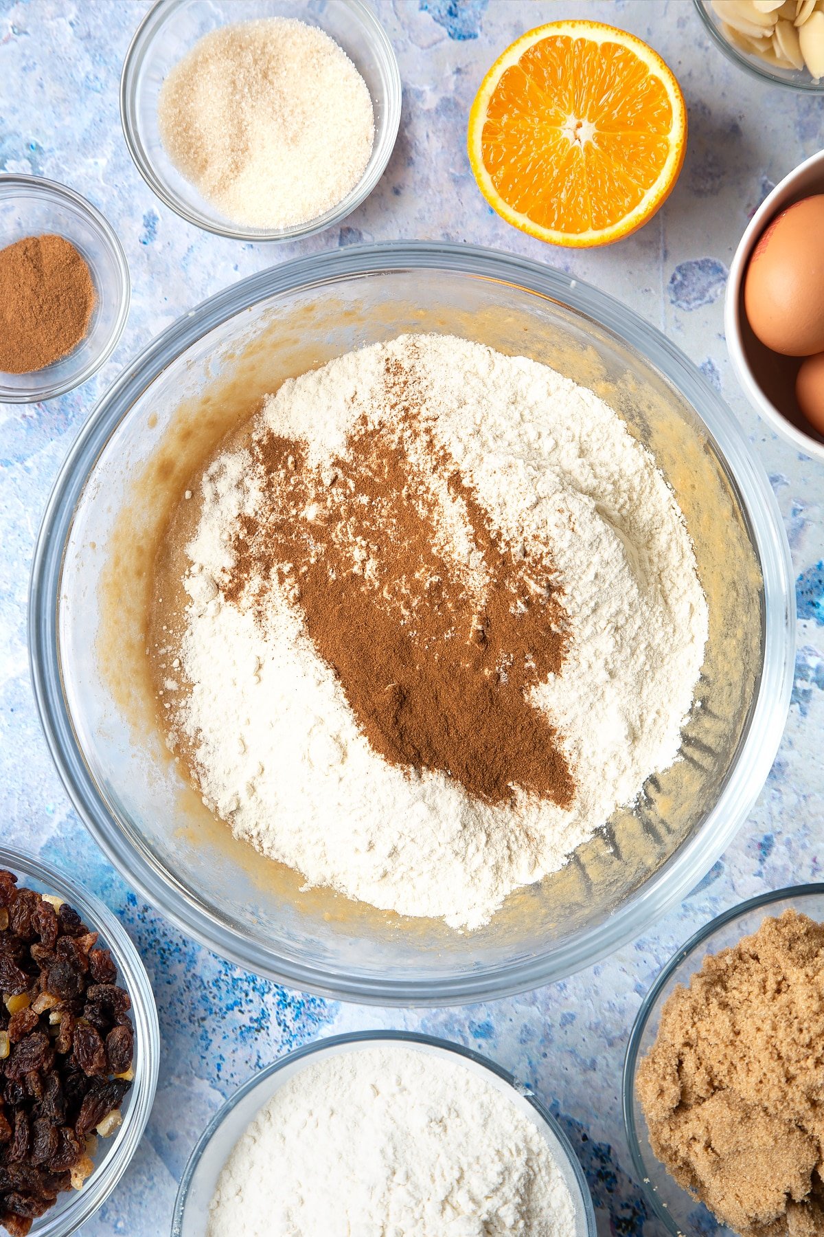 Overhead shot of flour and cinnamon in a large clear bowl