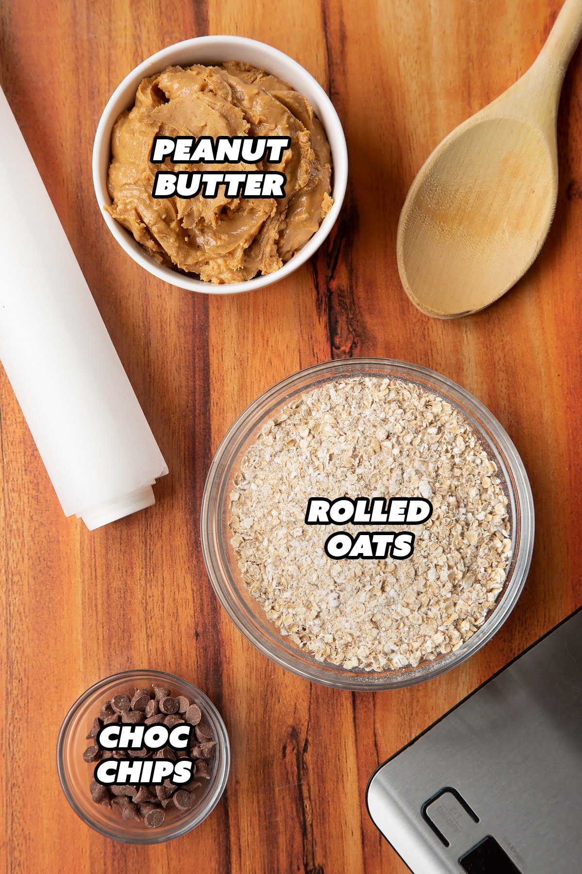 Three bowls containing peanut butter, oats and chocolate chips. 