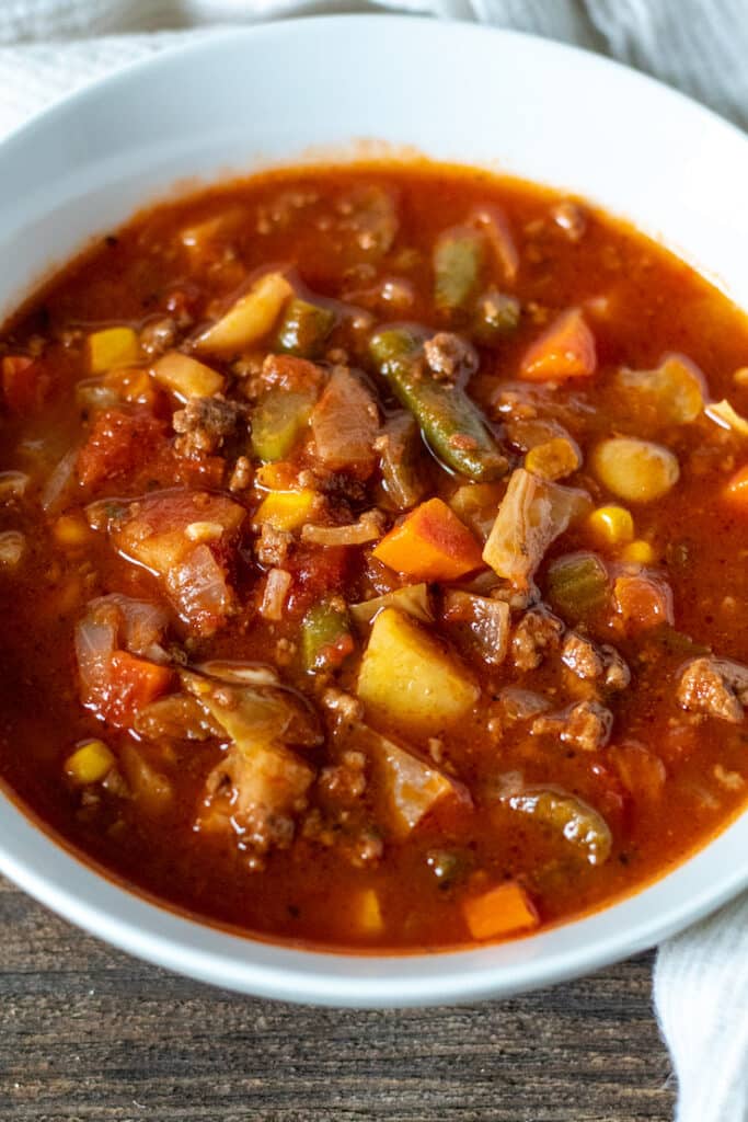 Close up of a white bowl filled with Vegetable Beef Soup.