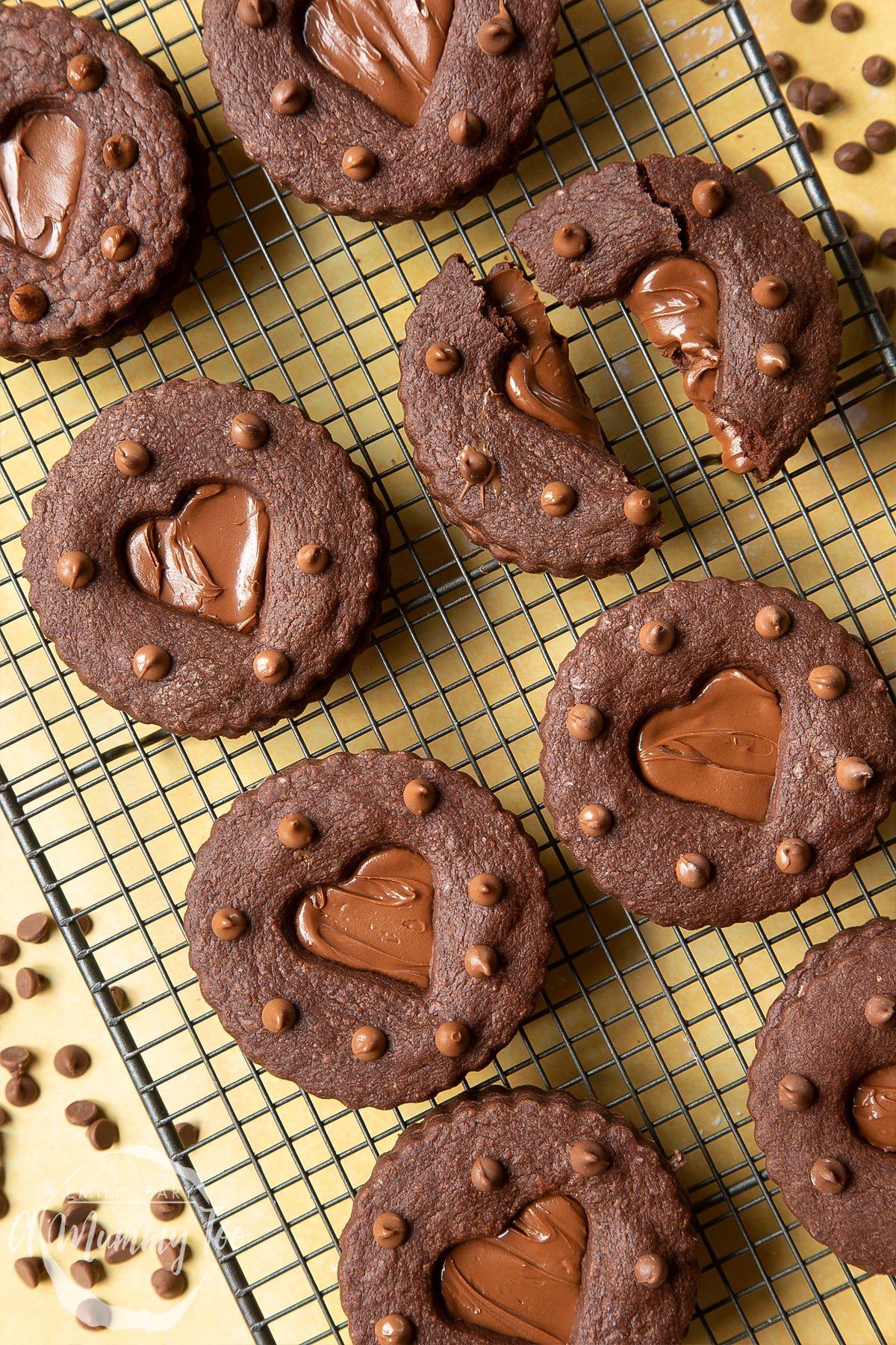 Nutella sandwich cookies on a cooling rack. One cookie is broken in half.