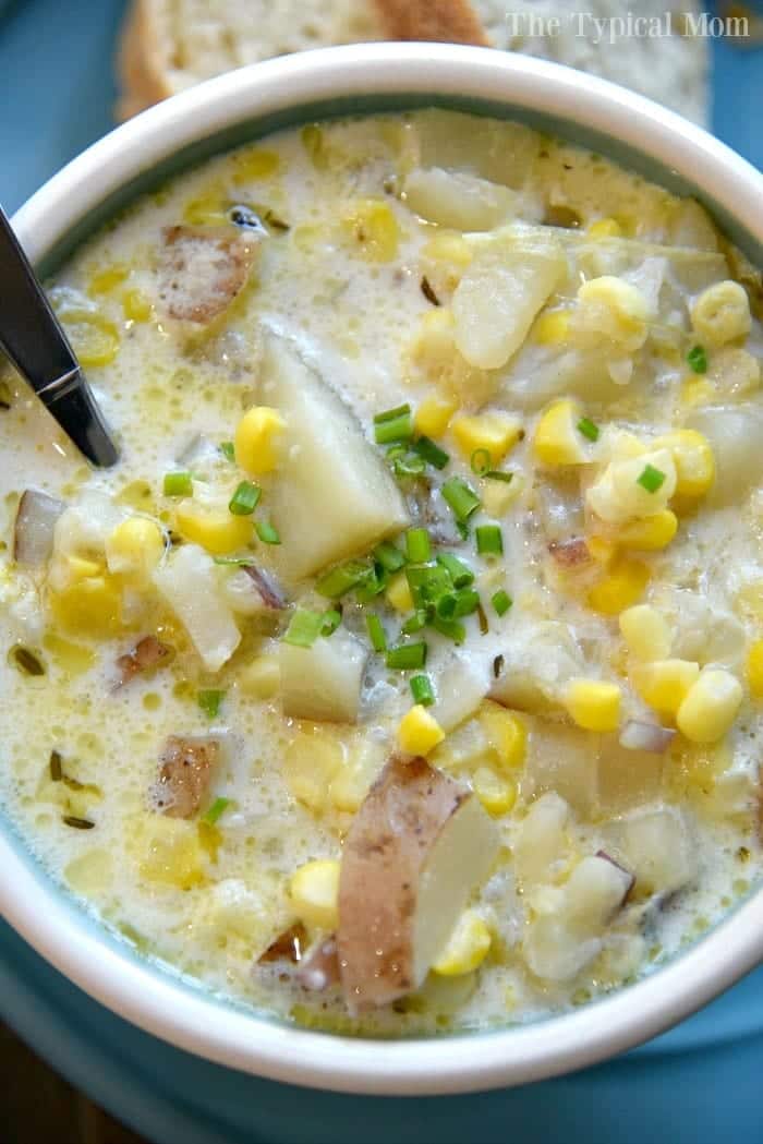 White bowl of Potato Corn Chowder on a blue background.