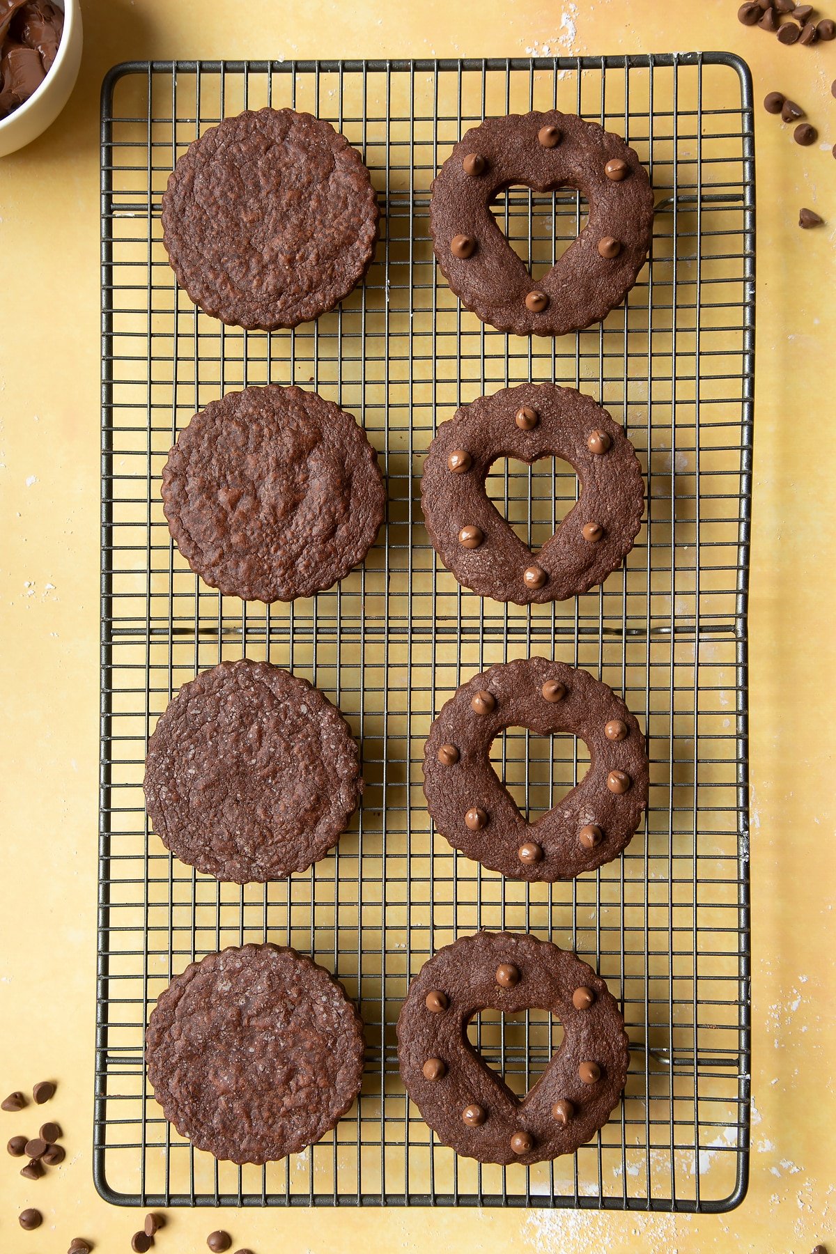 Chocolate sandwich cookies on a cooling rack ready to fill assemble. 