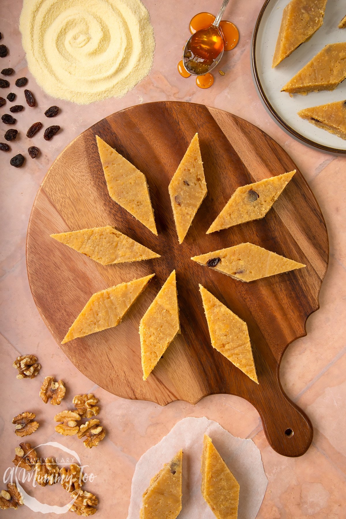 Sanwin-makin (aka golden semolina cake) on a wooden board. Ingredients surround the board.