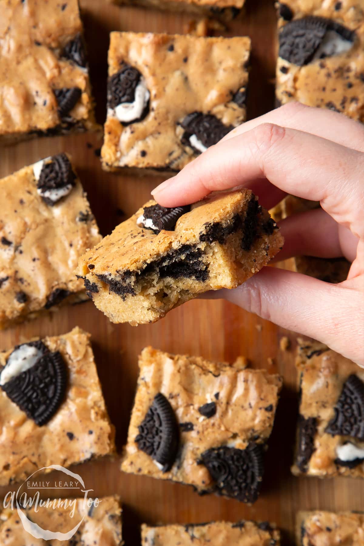 Overhead shot of a hand holding a Oreo Blondie with a bite missing from it