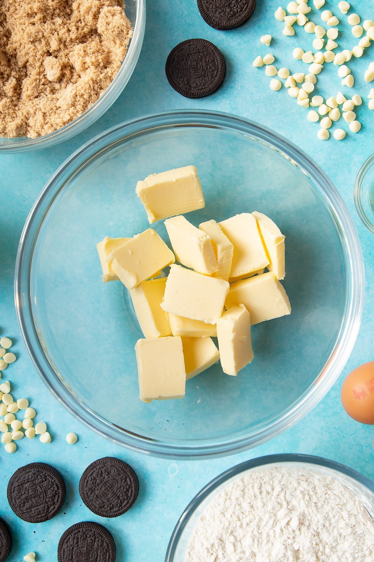 Overhead shot of butter chunks in a large clear bowl