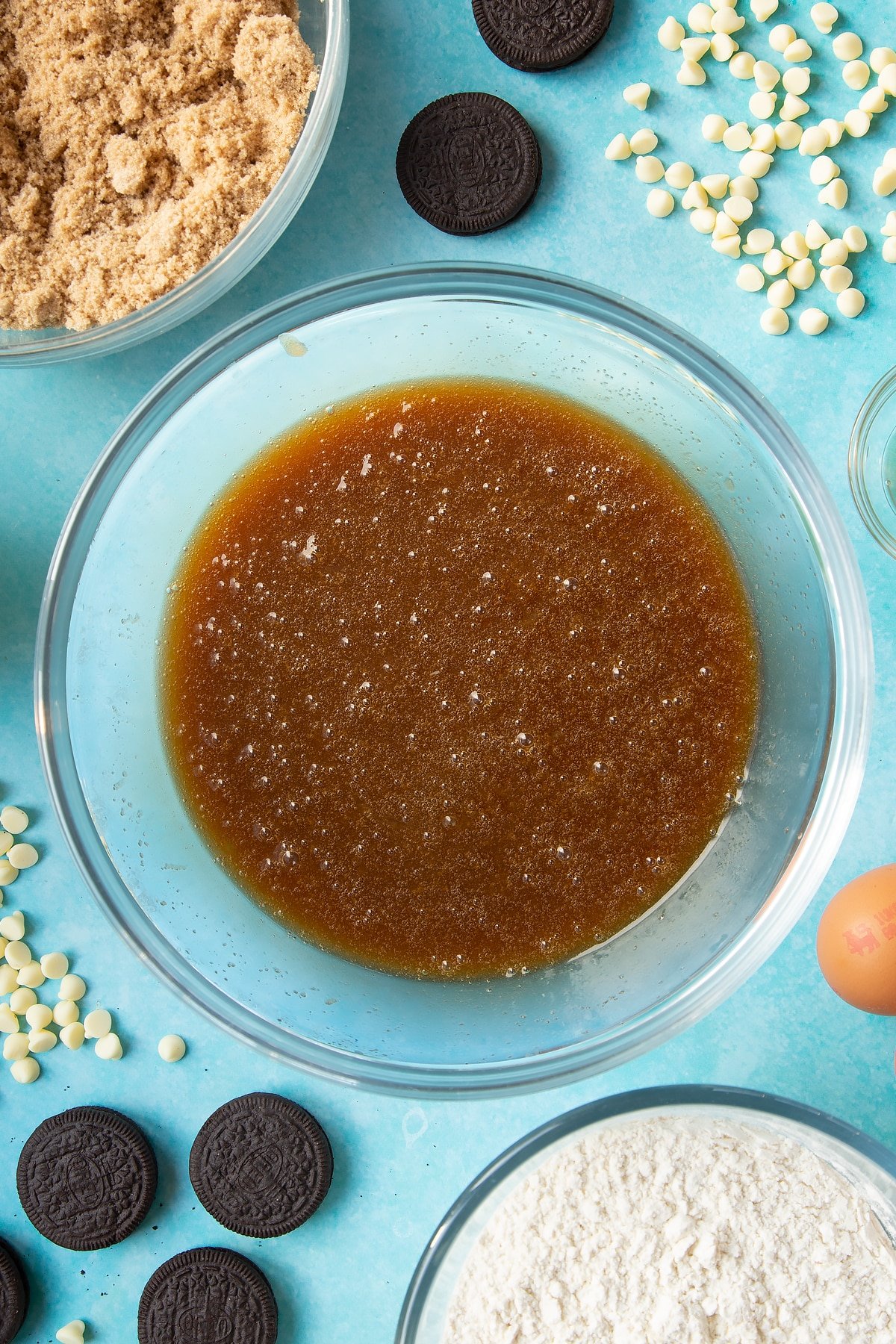 Overhead shot of melted butter, eggs and sugar mix in a large clear bowl