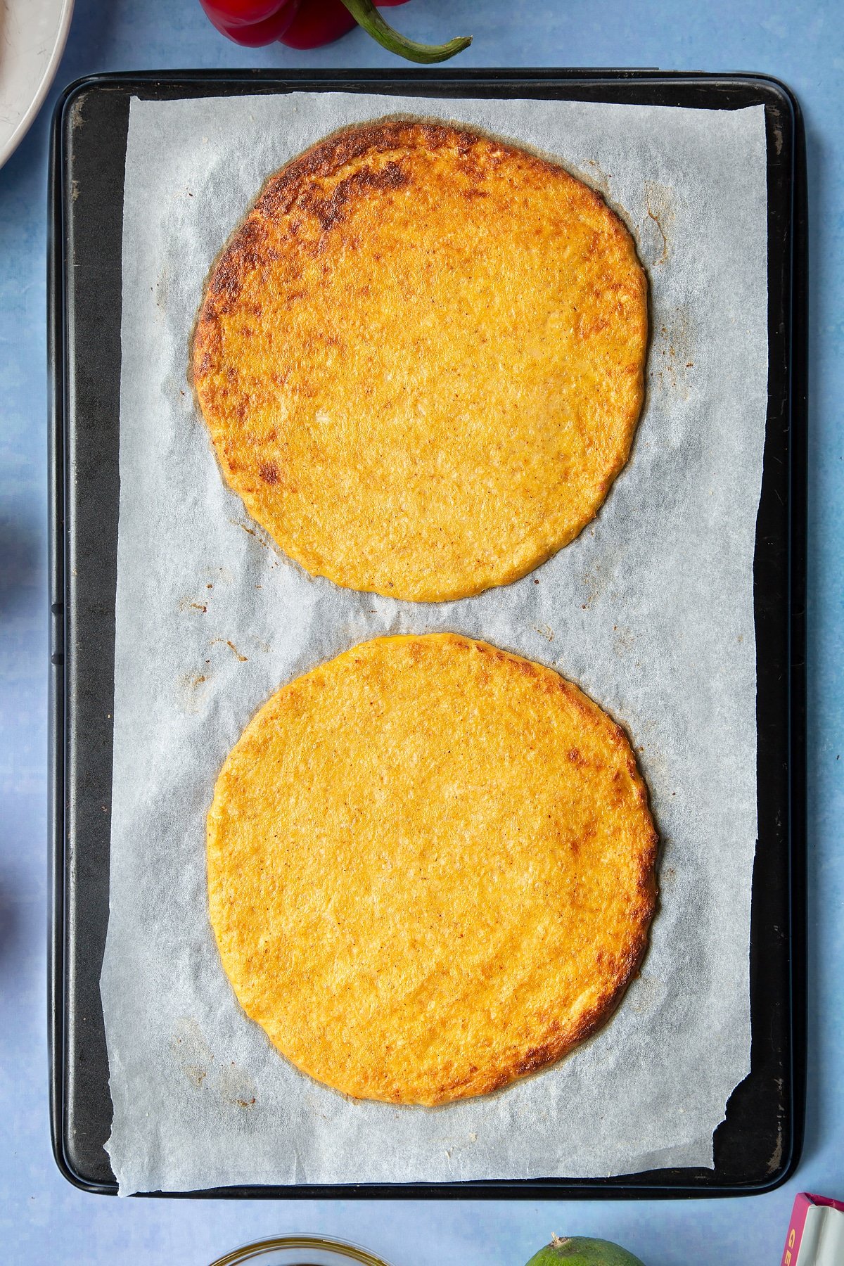 Cauliflower tortillas on a lined baking tray.