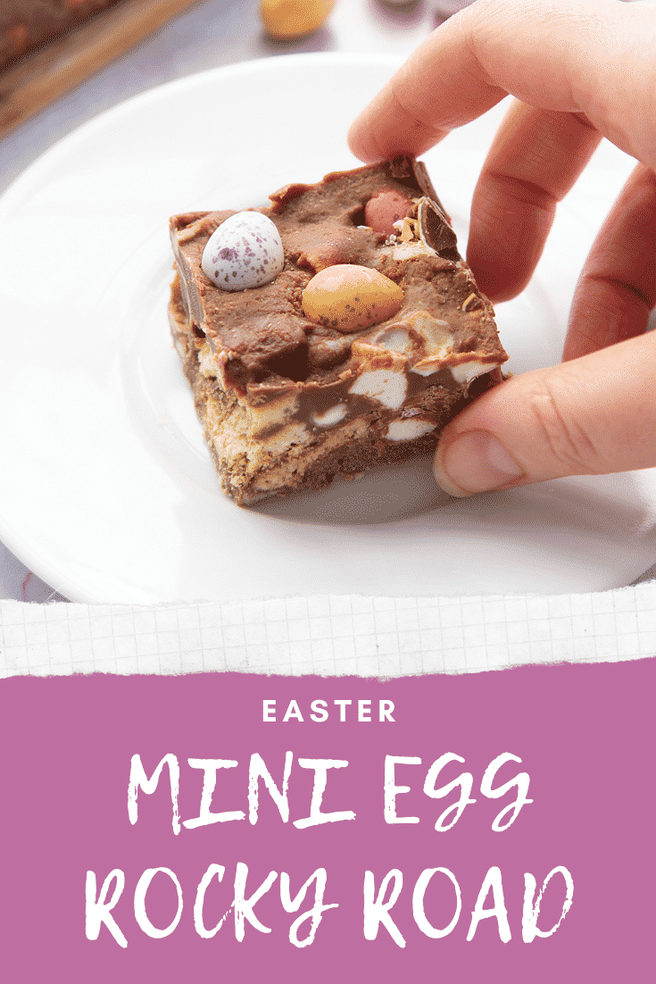 A piece of Mini Egg rocky road on a small white plate. A hand reaches for it. Caption reads: Easter Mini Egg rocky road