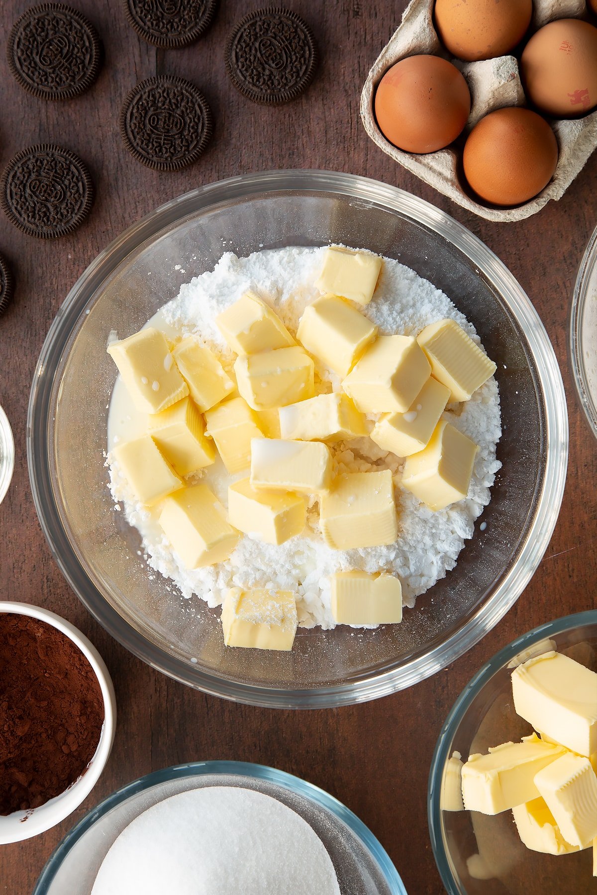 Overhead shot of butter chunks and icing sugar in a bowl