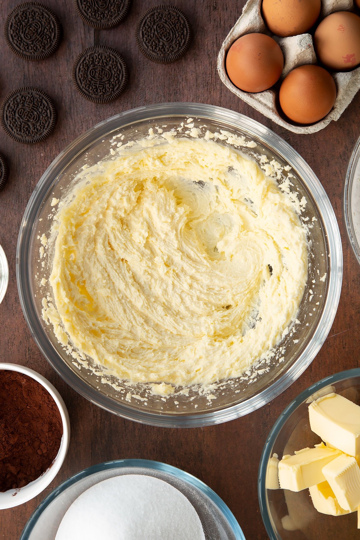 Overhead shot of butter and sugar mixed in a large clear bowl