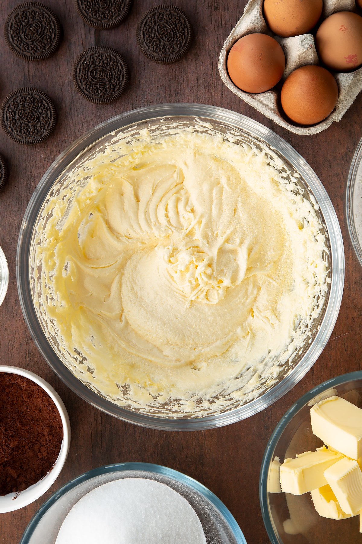 Overhead shot of cupcake batter mix whisked in a large clear bowl