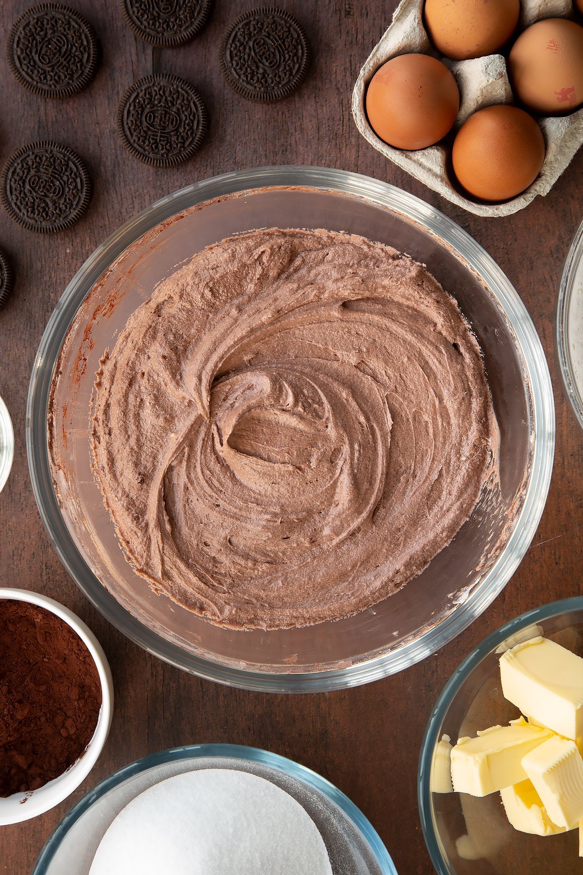 Overhead shot of whisked chocolate cupcake batter mix in a large clear bowl