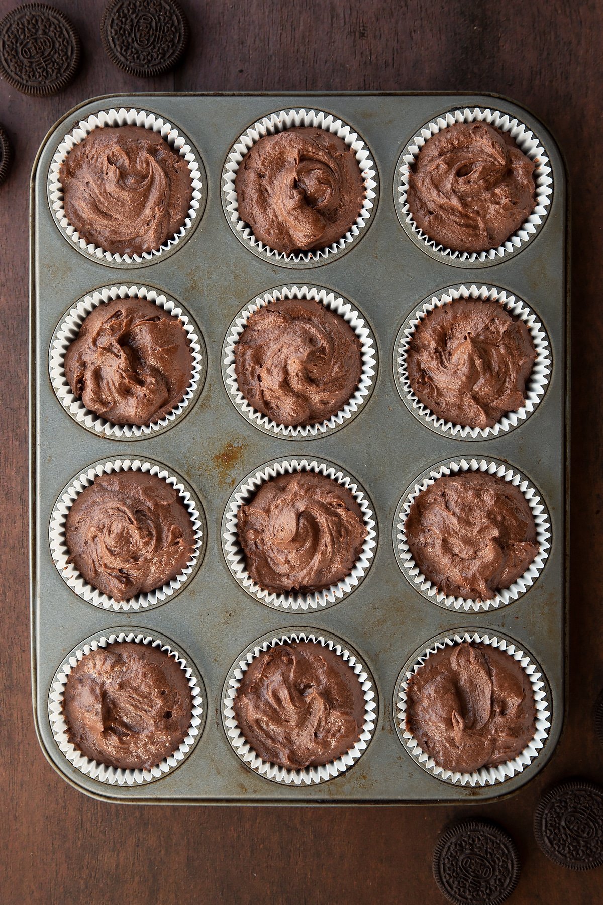 Overhead shot of chocoalte cupcake batter mix filled cupcake liners in a cupcake tray