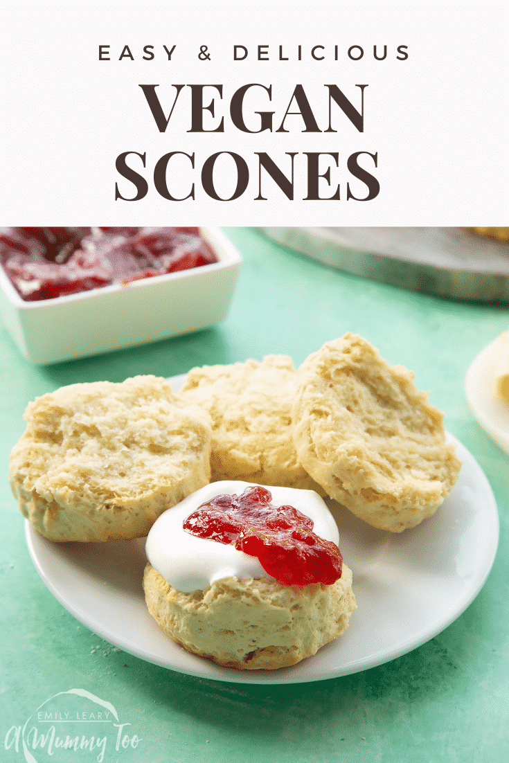 Two dairy free scones on a white plate. They are split in half and one is topped with jam and vegan whipped cream. Caption reads: easy & delicious vegan scones