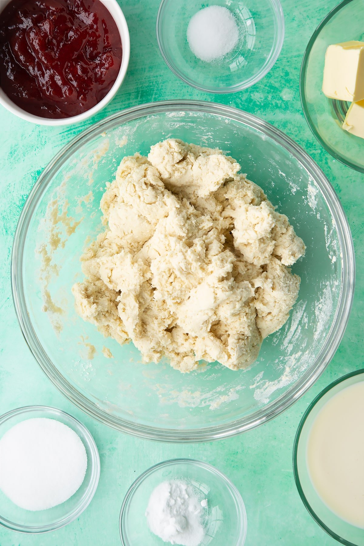 Dairy free scone dough in a bowl. Ingredients to make dairy free scones surround the bowl.