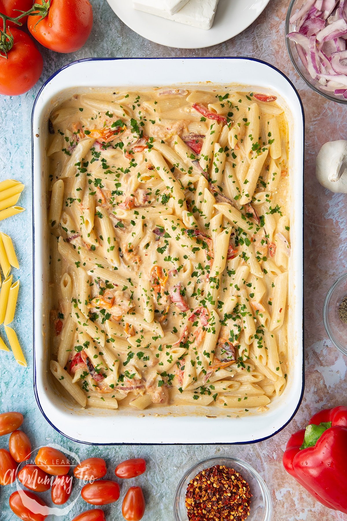 A tray of baked feta pasta garnished with parsley.