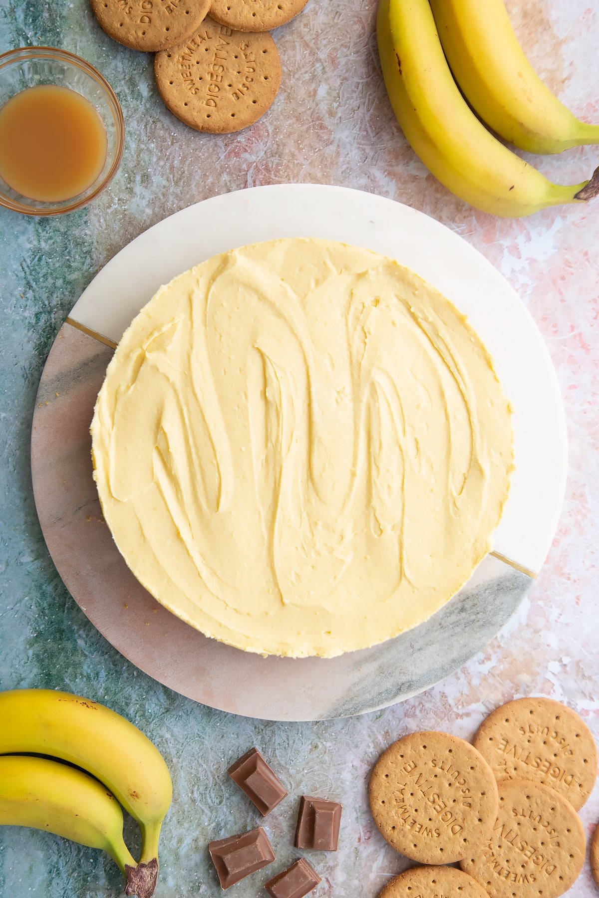 Banoffee pie cheesecake on a white and pink marble board. 