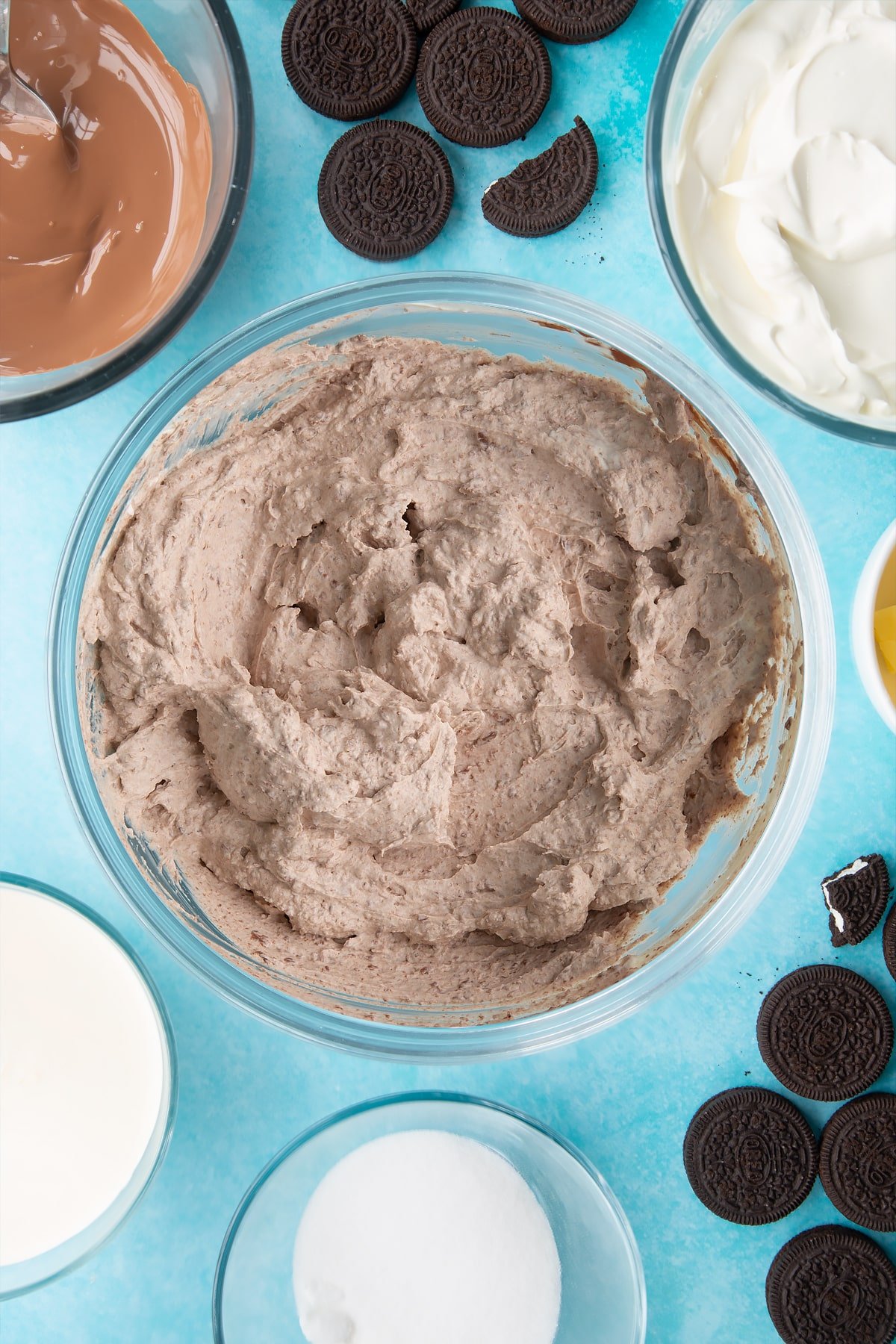 Overhead shot of whipped ingredients mixed with melted chocolate in a large clear bowl