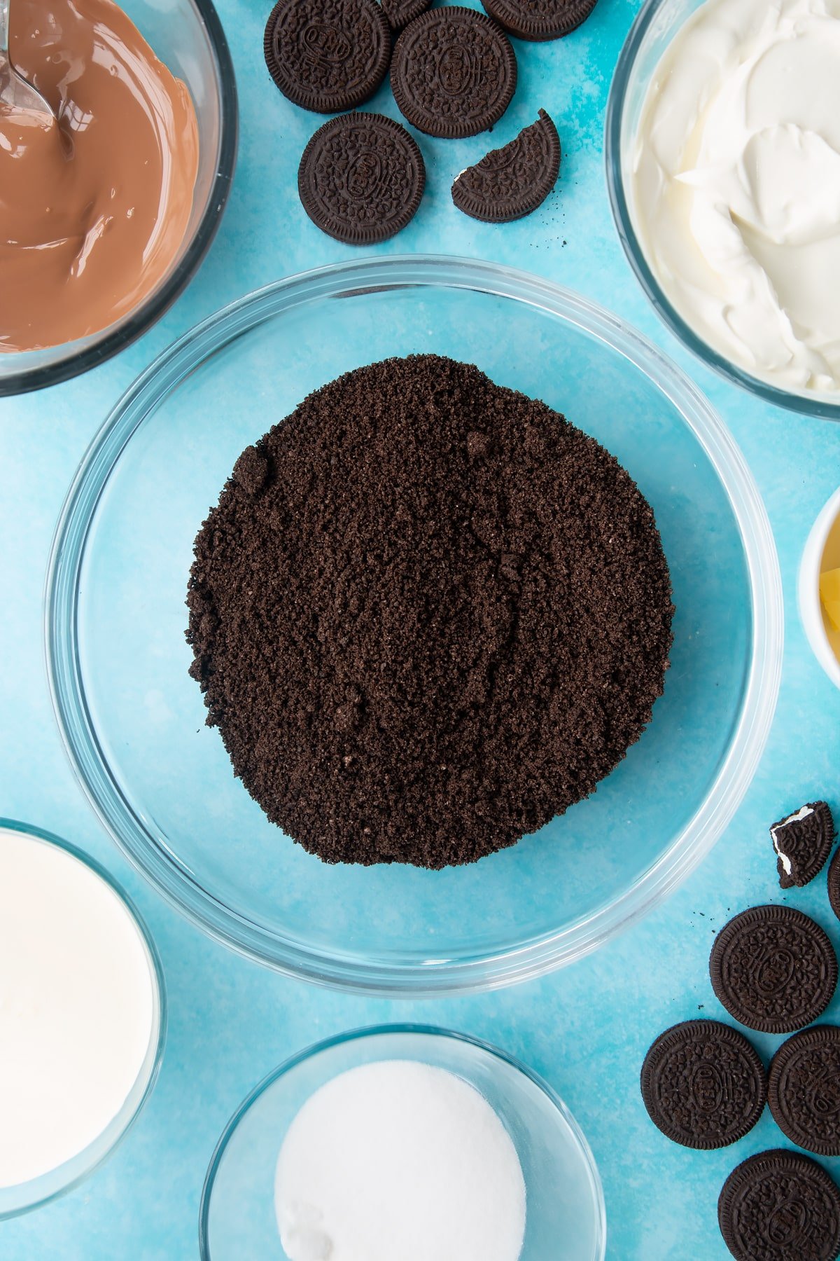 Overhead shot of oreo biscuits crumbed in a large clear bowl