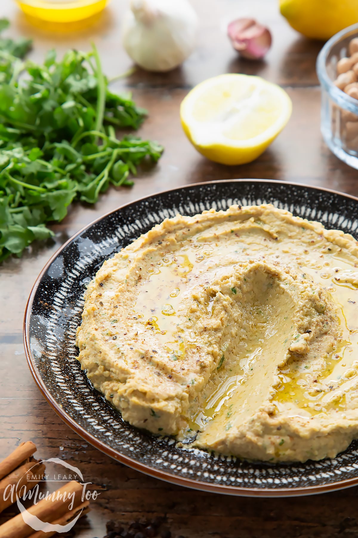 Cinnamon hummus served in a black and white bowl. It has a line drawn through it.