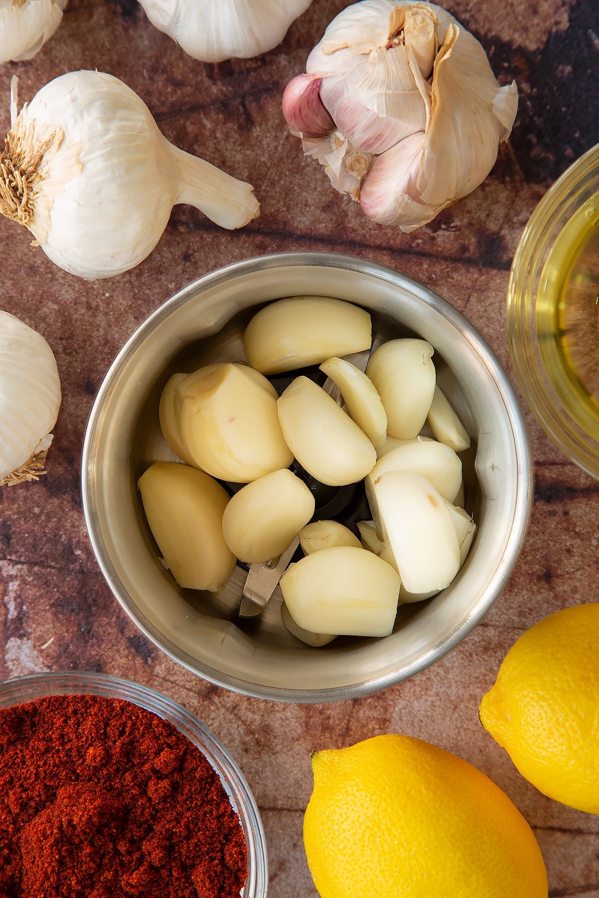 Overhead view of skinned garlic cloves piled in a metal grinder