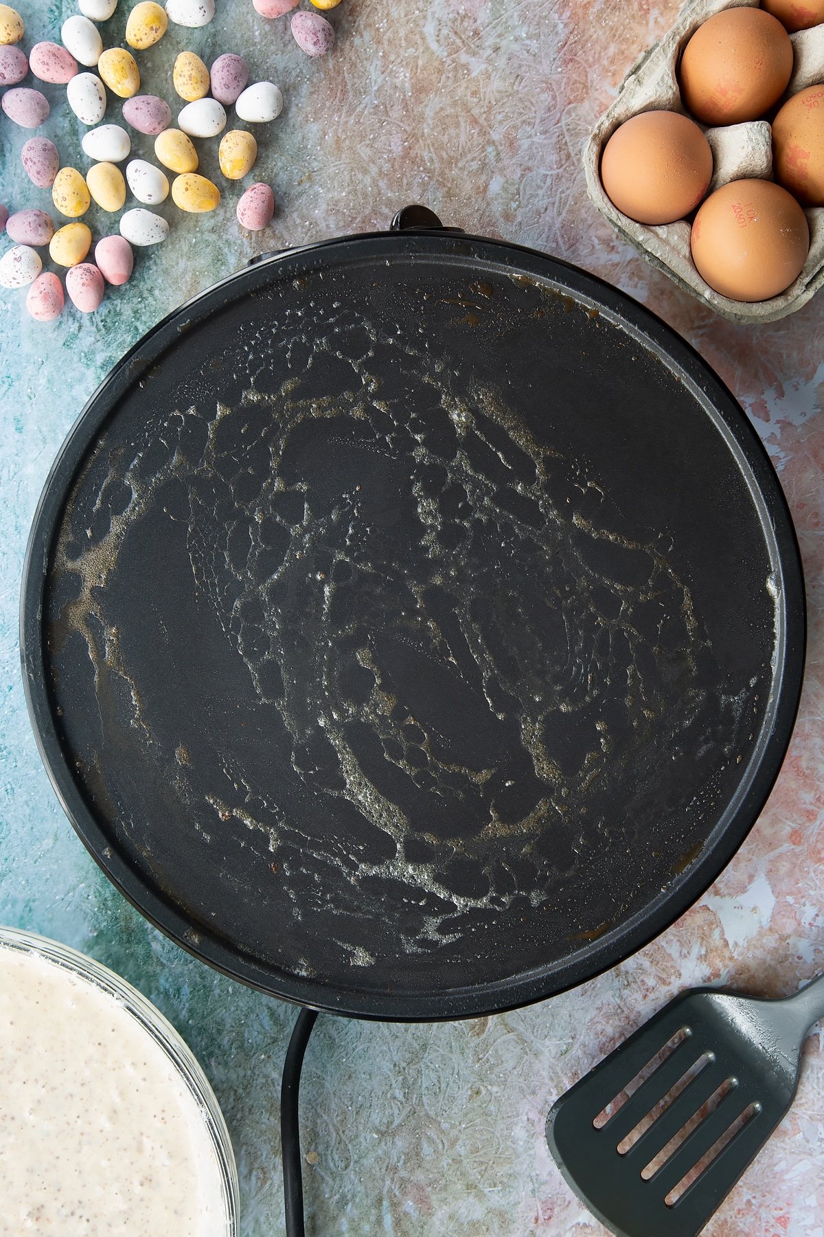 Melted butter on a hot pan. Ingredients to make Mini Egg pancakes surround the pan.