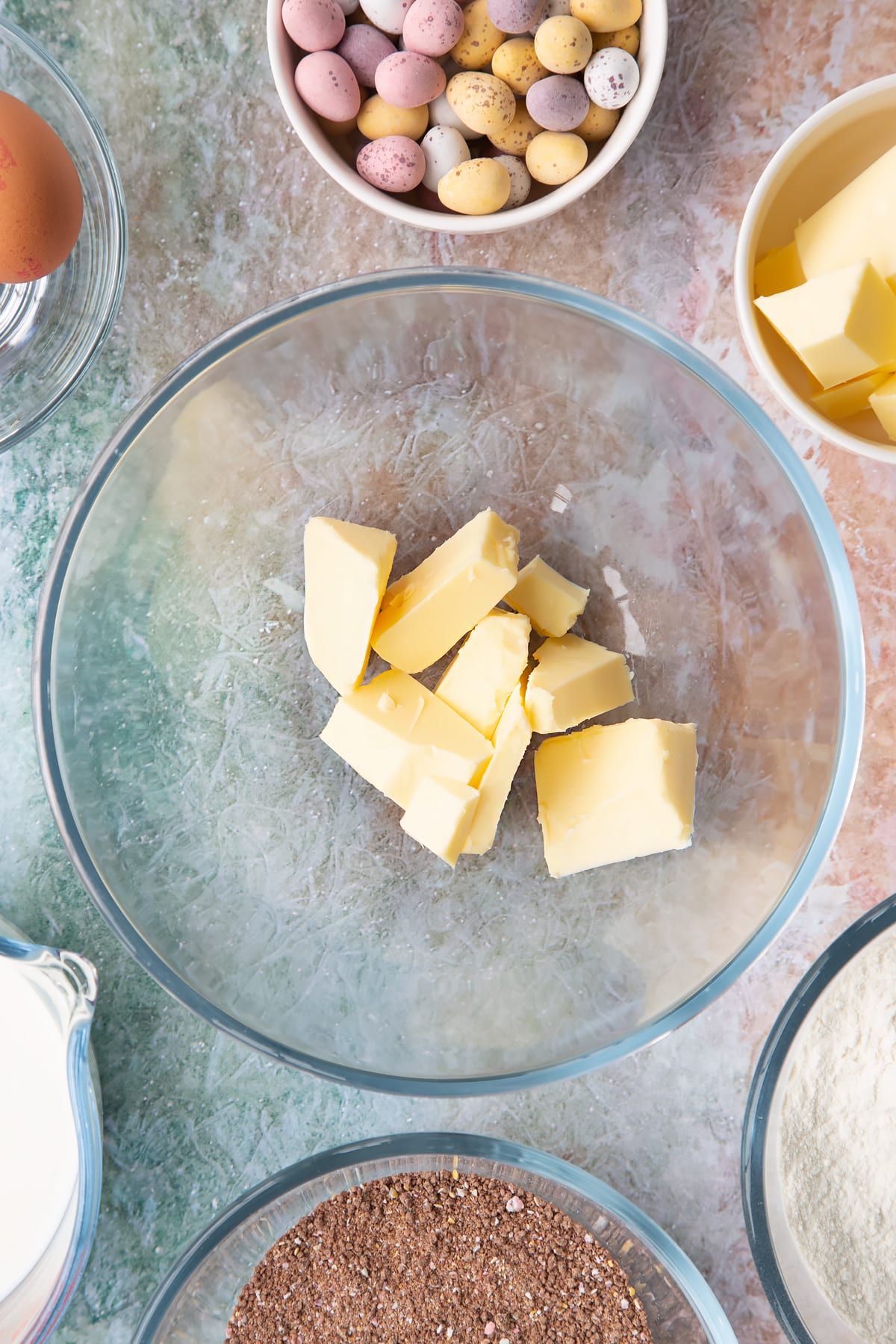 Butter in a bowl. Ingredients to make Mini egg waffles surround the bowl.