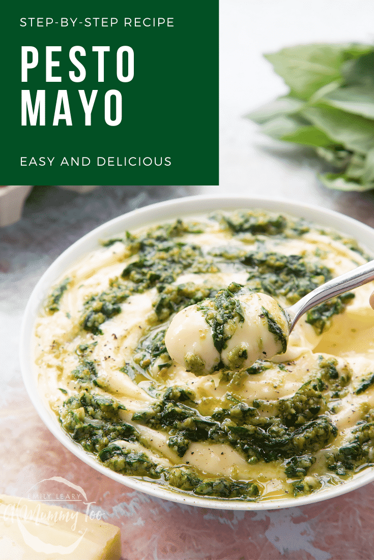 Pesto mayo in a white bowl. The pesto and mayonnaise are swirled together. A hand holds a spoonful above the bowl. Caption: step-by-step recipe pesto mayo easy and delicious