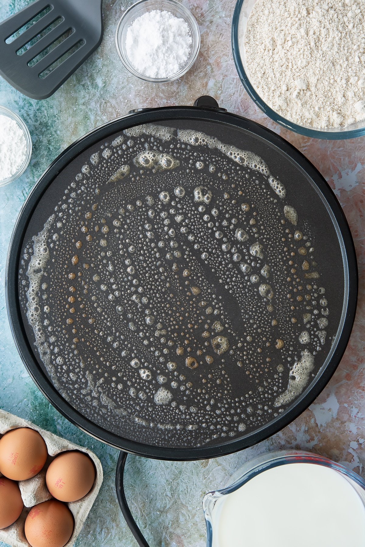 Overhead shot of a hot plate with melted butter spread around.