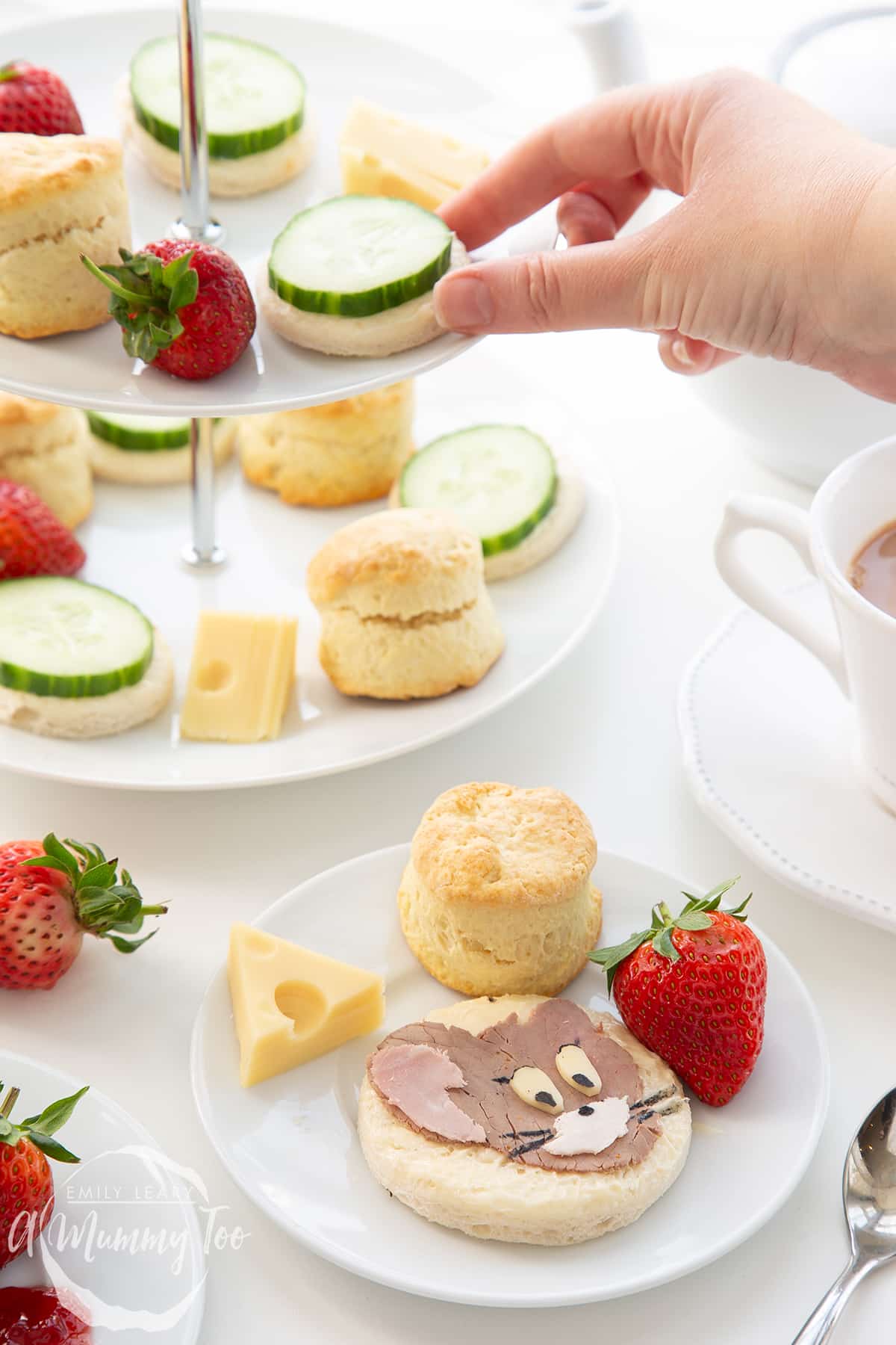 Tom and Jerry afternoon tea on a cake stand with a combination of scones, sandwhiches, cheese and strawberries. 