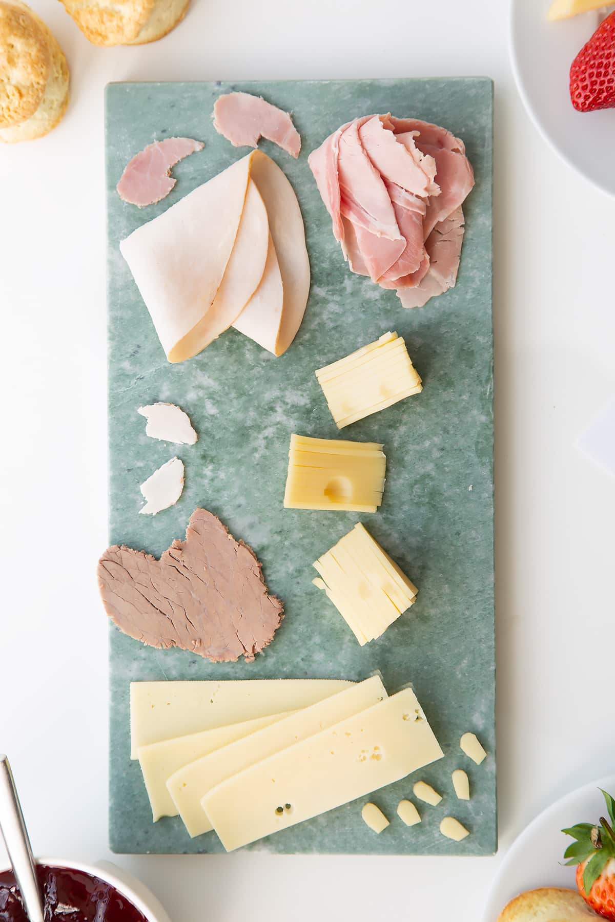 Overhead shot of the cheese wedge from the Tom and Jerry afternoon tea being assembled. 