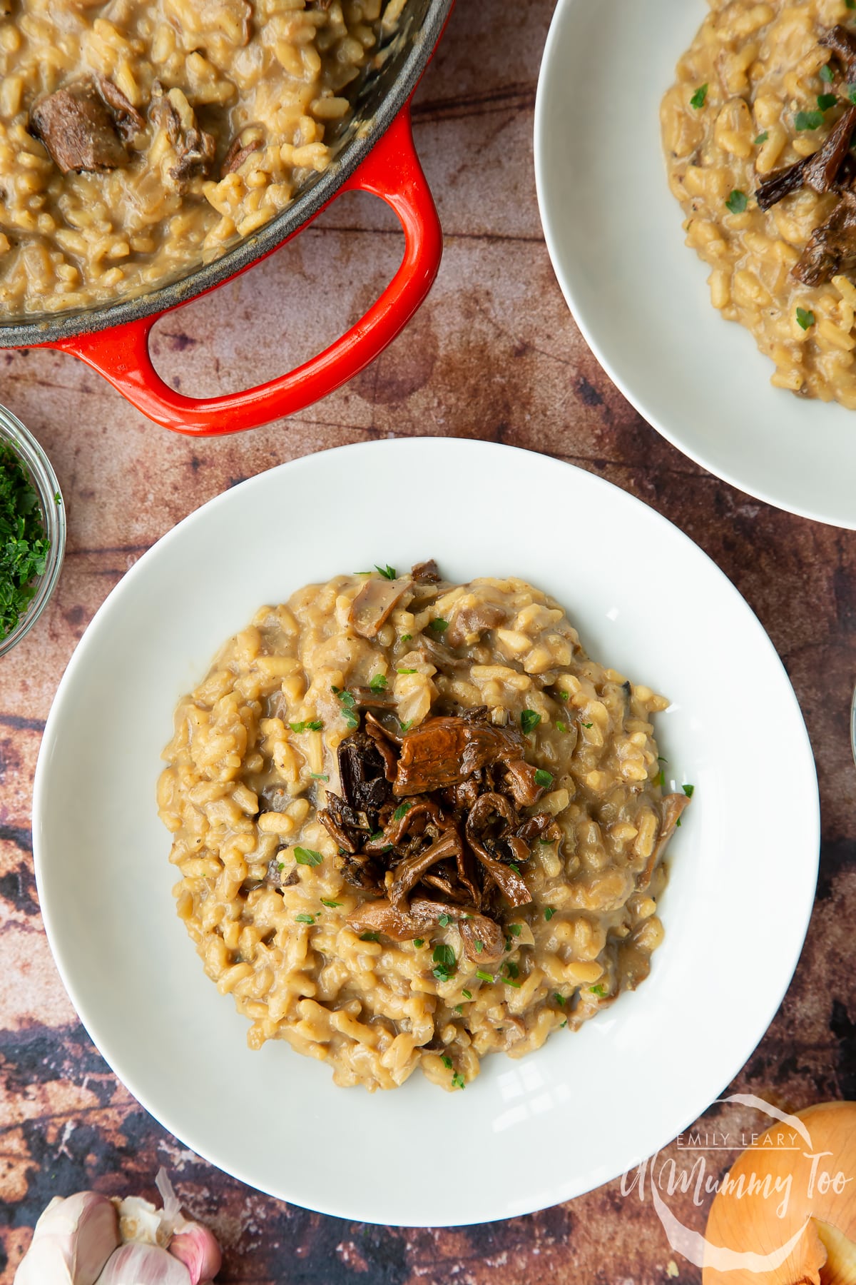 Vegan mushroom risotto in a shallow white bowl, shown from above.