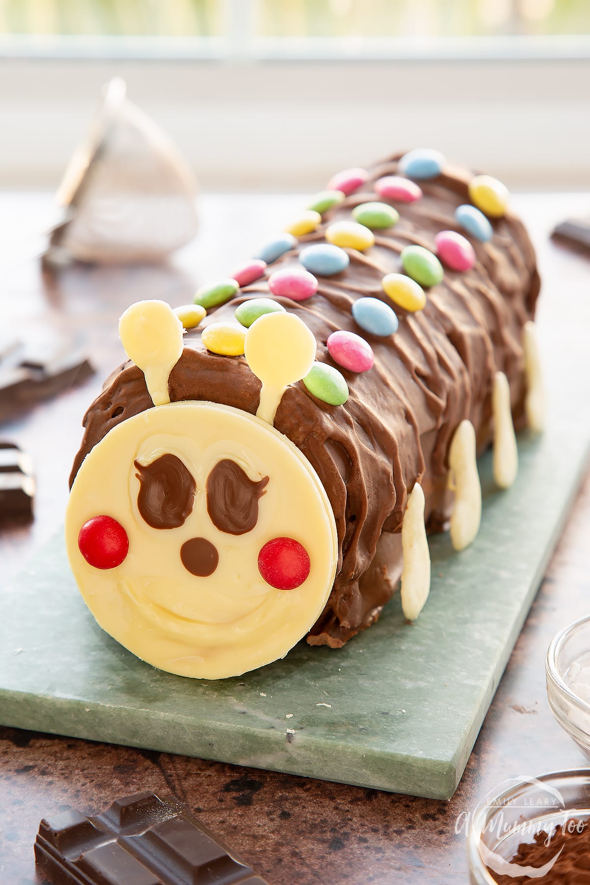 A caterpillar cake on a grey marble board.