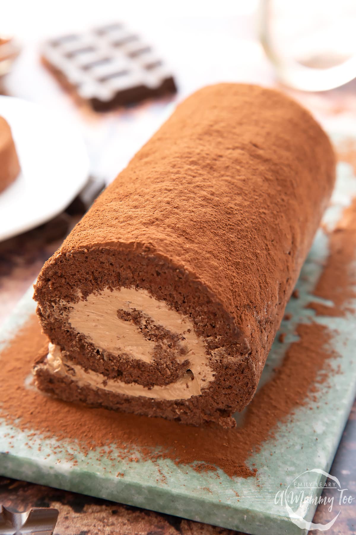 A Chocolate Swiss roll on a grey marble board.