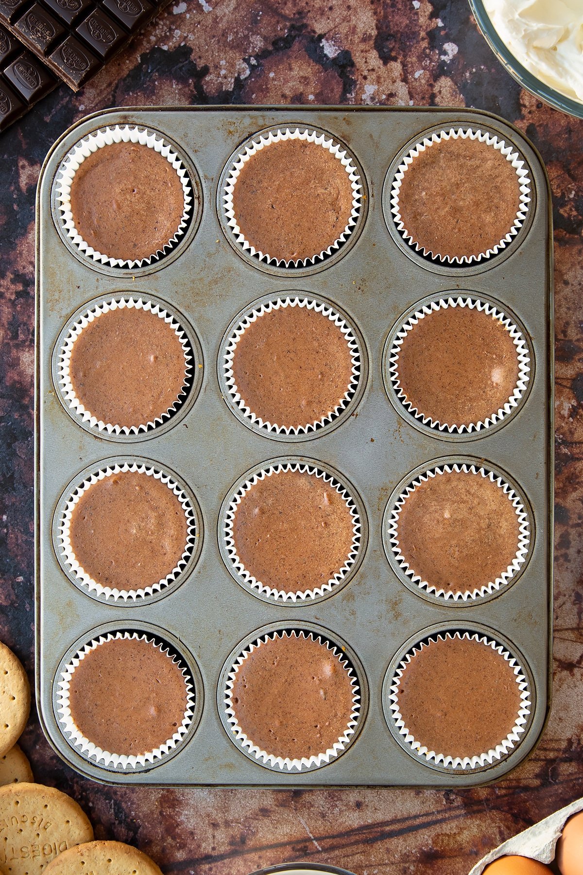 Chocolate cheesecake cupcakes, freshly baked in a muffin tray.