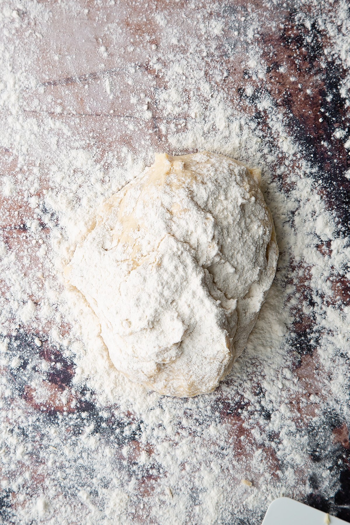 Overhead shot of white dough on a floured surface covered in flour