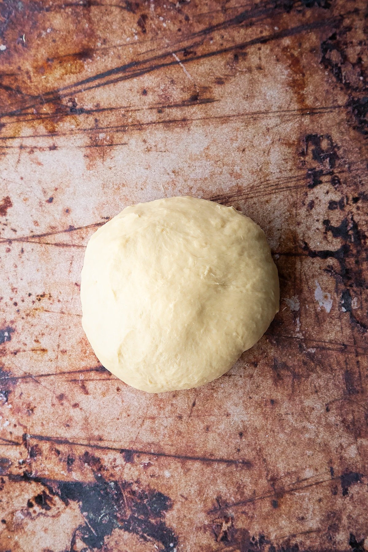 Overhead shot of white dough ball formed on a clean surface