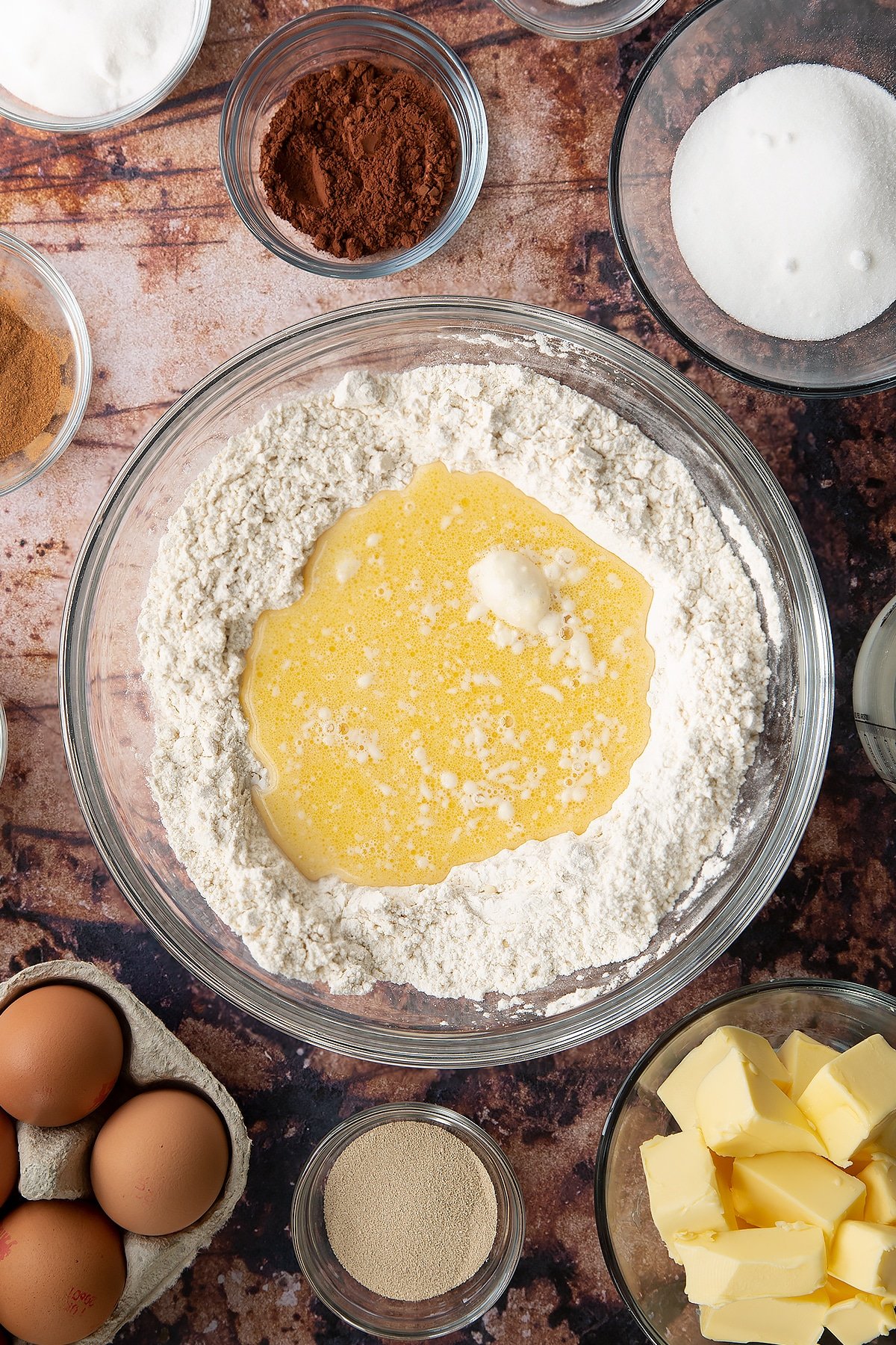 Overhead shot of the flour mixture around the edges and milk mixture in the centre of a large clear bowl