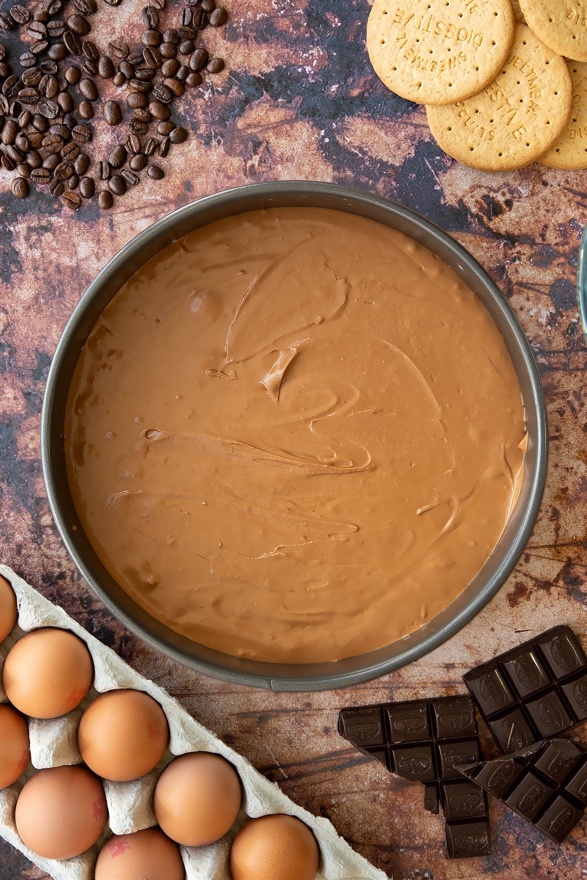 Overhead shot of cheesecake mix in a large metal cake tin