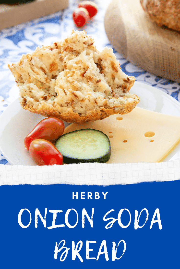 Onion soda bread on a white plate with cheese and salad. A hand holds a piece. Caption reads: herby onion soda bread