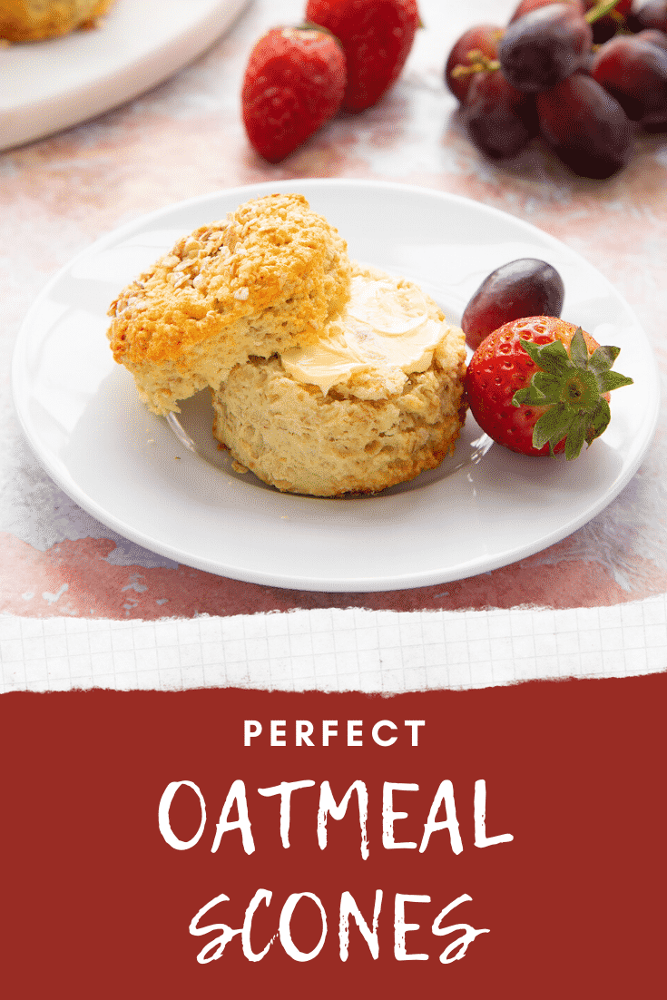 Oatmeal scone on a white plate. It has been split and buttered. Caption reads: Perfect Oatmeal Scones