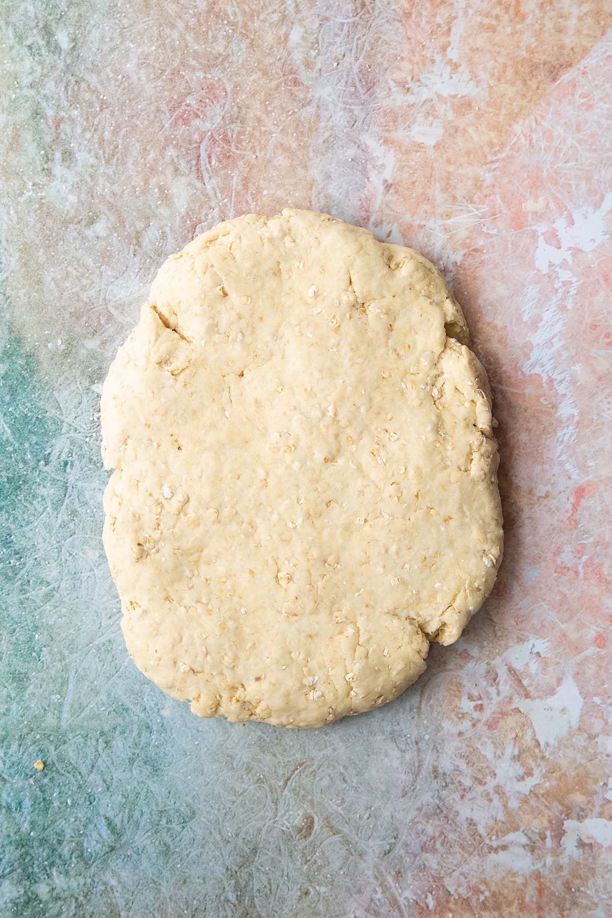 Oatmeal scone dough pressed to a thick slab.