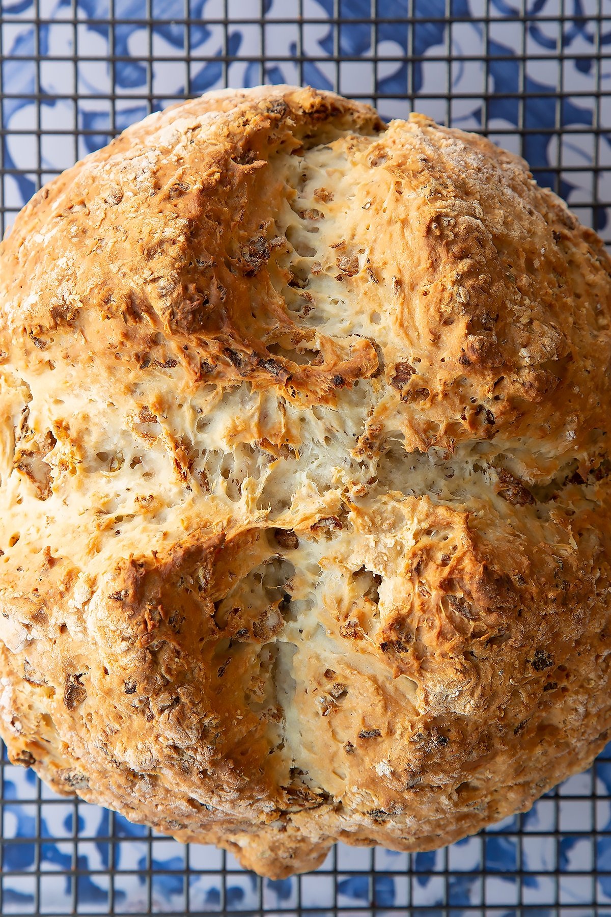 A loaf of onion soda bread cooling on a wire rack, shown from above.