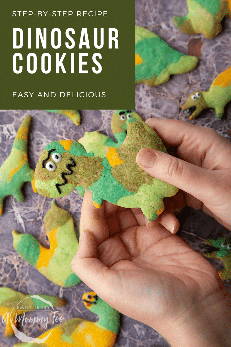 graphic text step-by-step recipe DINOSAUR COOKIES above Overhead shot of a hand holding a green dinosaur sugar cookie with website URL below