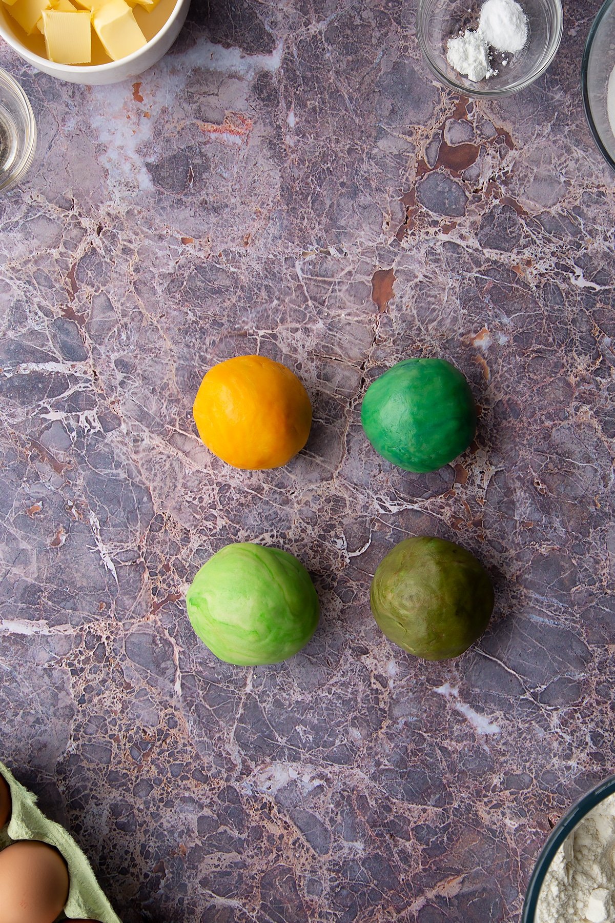 Overhead shot of 4 coloured cookie dough balls