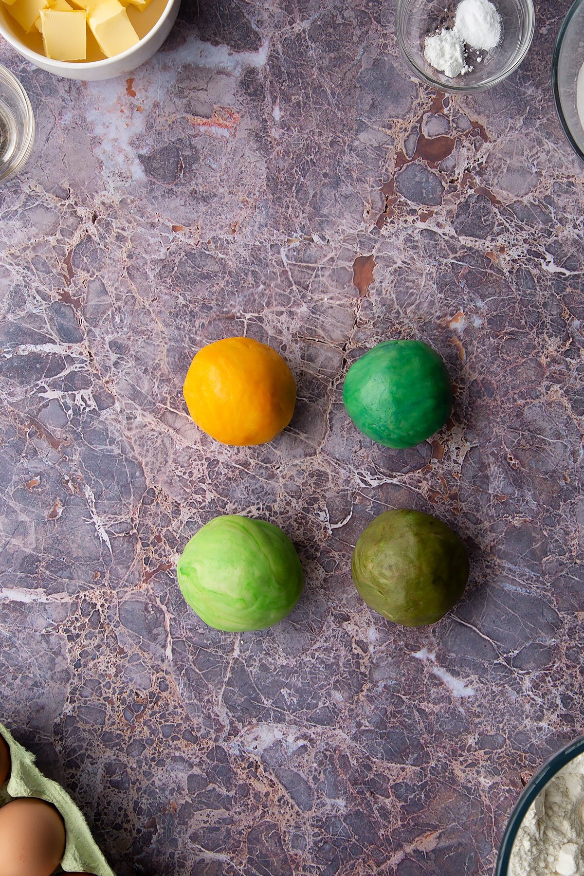 Overhead shot of 4 coloured cookie dough balls 