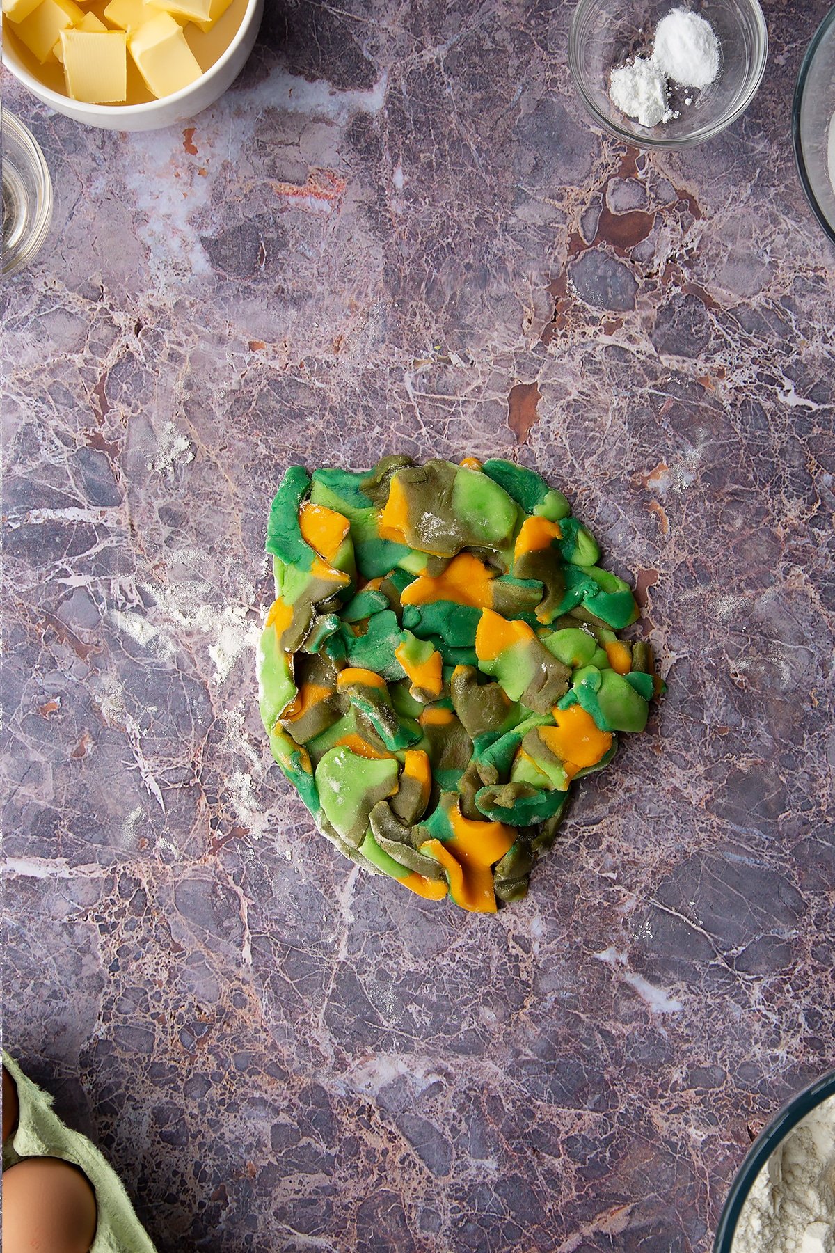 Overhead shot of small chunks of coloured cookie dough pieces gathered together in a dough ball
