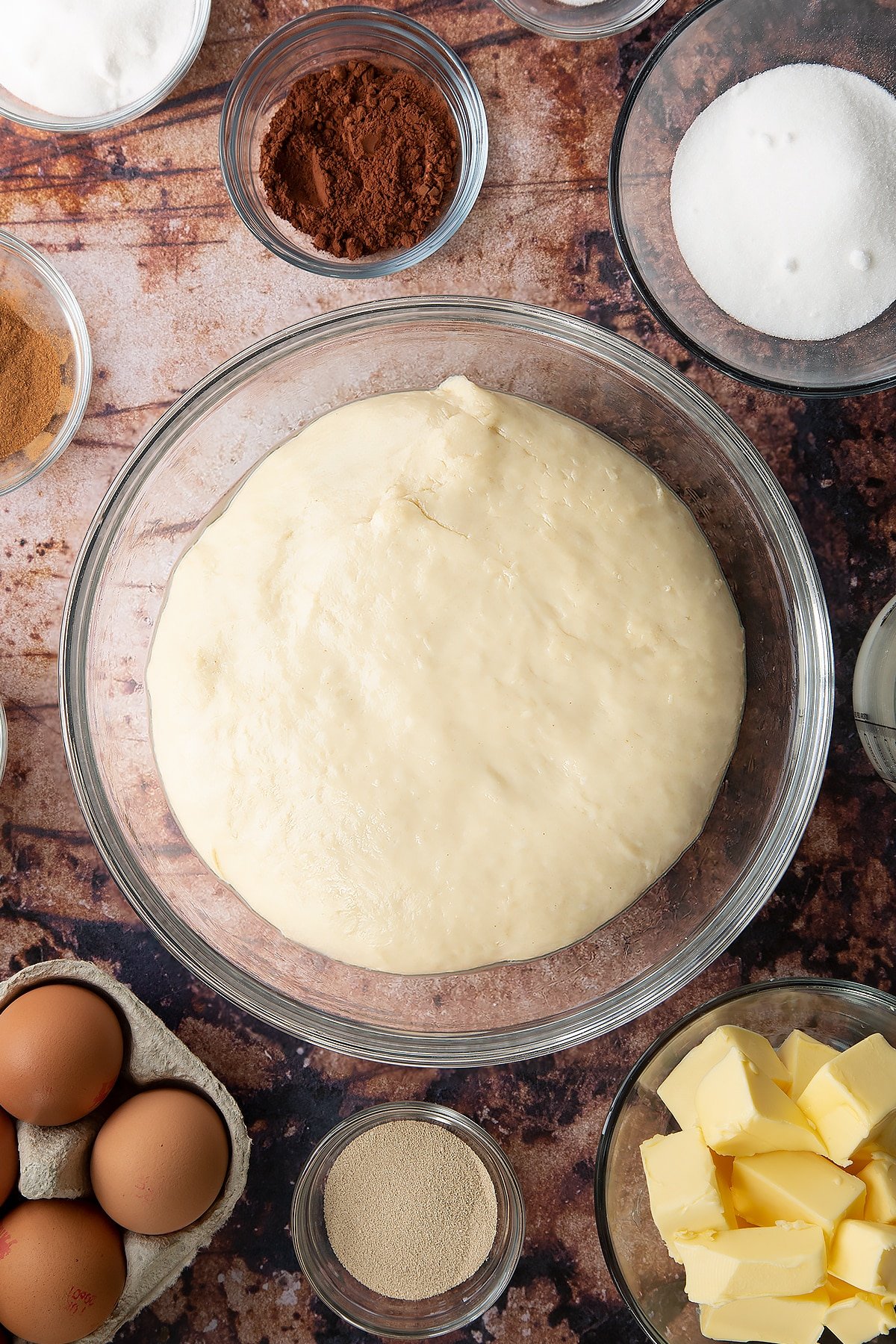 Overhead shot of proved bread dough in a large clear bowl.